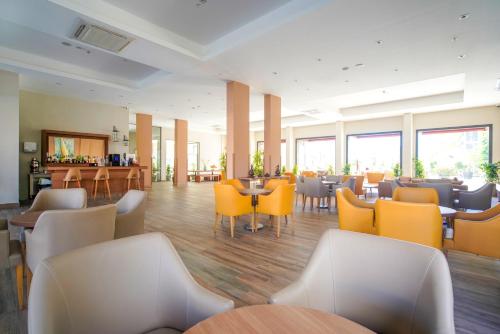 a restaurant with yellow chairs and tables and windows at Ada Julian Marmaris in Marmaris