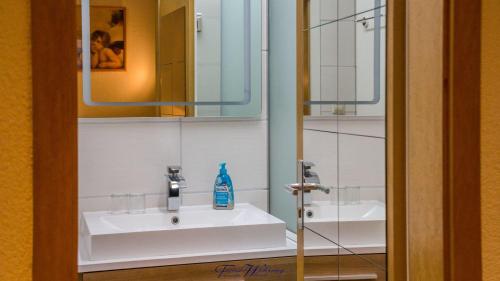 ドレスデンにあるFerienwohnung-Franziska-Wuensche-Wohnung-1のバスルーム(白い洗面台、鏡付)