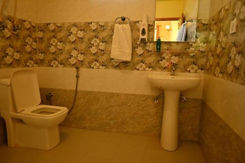 a bathroom with a toilet and a sink at Cascade Mountain Retreat Manali in Manāli