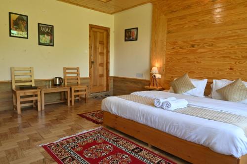 a bedroom with a bed and a table and a desk at Cascade Mountain Retreat Manali in Manāli