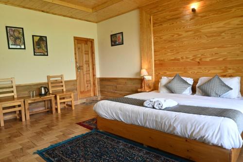 a bedroom with a bed and a desk in a room at Cascade Mountain Retreat Manali in Manāli