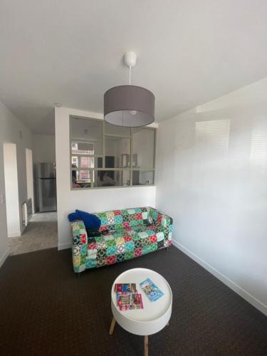 a living room with a couch and a table at Séjourner chez Mina in Lille