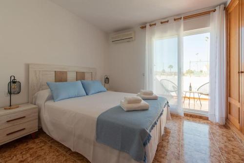 una camera da letto con un letto grande e una grande finestra di Sunny Home Gran Alacant a Gran Alacant