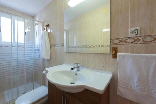 un bagno con lavandino, doccia e specchio di Sunny Home Gran Alacant a Gran Alacant