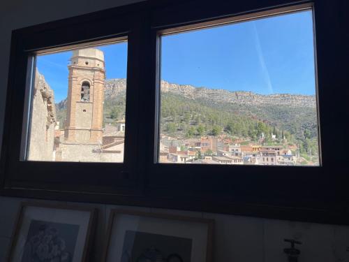 a view of a clock tower from a window at Casa Rural Cal Vellet del Priorat in La Vilella Baixa