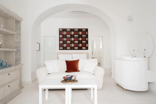 een witte woonkamer met een witte bank en een tafel bij Villa Mariuccia Capri in Capri