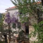 a stone building with a tree in front of it at Apartments Villa Ina in Brseč