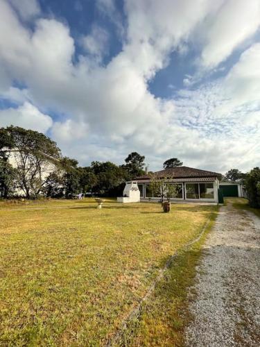 une maison dans un champ avec une cour en herbe dans l'établissement Villa près de la plage, à Lège-Cap-Ferret
