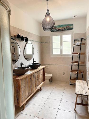 une salle de bain avec deux lavabos et un miroir dans l'établissement Villa près de la plage, à Lège-Cap-Ferret