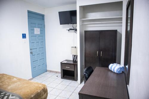 sypialnia z łóżkiem, stołem i drzwiami w obiekcie Borinquen Beach Inn w mieście San Juan