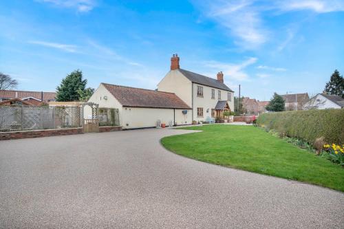 a house with a driveway in front of a yard at Rose Cottage at Orchard House in Rampton