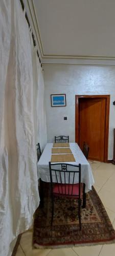 a dining room with a table with a white curtain at Cozy Appartement in Midelt in Midelt