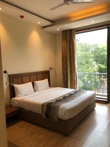 a bedroom with a bed and a large window at UDS Villa - Next to VFS, Walking to Connaught Place in New Delhi