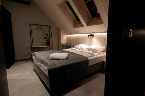 a bedroom with a bed with two towels on it at Widać Wydmy in Łeba