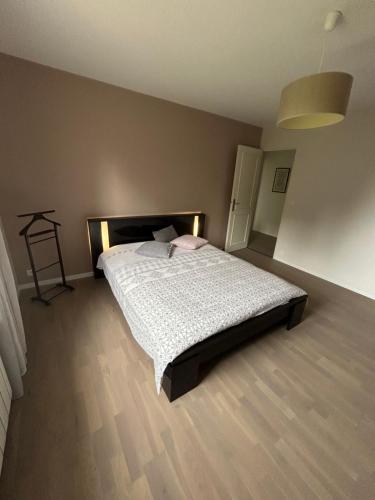 a bedroom with a bed with a white comforter at Charmante maison proche des 24h du Mans in Le Mans
