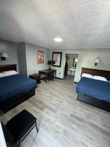 a large room with two beds and a desk at Acorn Motel in Black Mountain