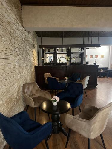 un restaurante con sillas, mesas y una pared de ladrillo en Hotel Soimul, en Poiana Brasov