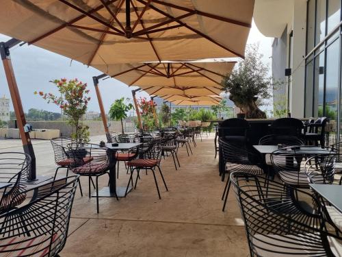 an empty patio with tables and chairs under umbrellas at Soho Suites in Bar