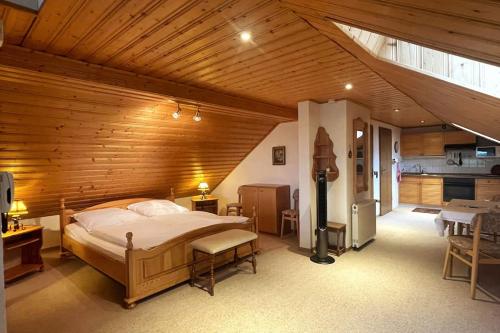 sypialnia z dużym łóżkiem i drewnianym sufitem w obiekcie Haus PANORAMA - Appartement Auszeit 5 w mieście Braunlage