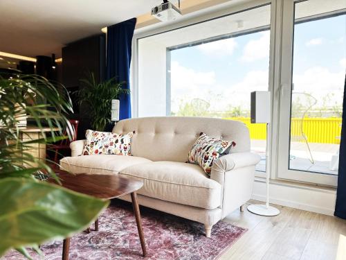 a living room with a couch and a table at Ambient lounge with sundeck and free parking in Bratislava