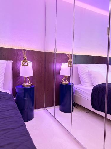 a room with two beds with mirrors and two lamps at Ambient lounge with sundeck and free parking in Bratislava
