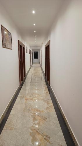 an empty hallway with a long room with white walls at Hotel Swastik Bhumi in Gaya