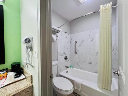 een badkamer met een bad, een toilet en een douche bij Suite 16 Motel in Gore