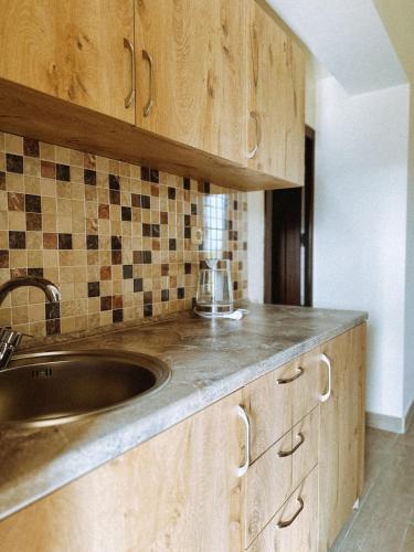 a kitchen with wooden cabinets and a sink at Sevan - Artanish Beach Resort in Artanish