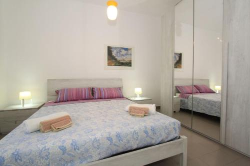 1 dormitorio con 1 cama con 2 toallas en Stella apartments, en Lido di Pomposa