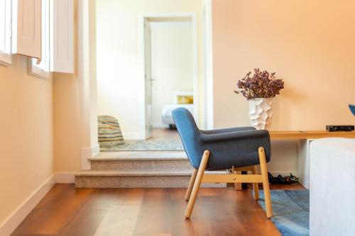a blue chair sitting in front of a desk in a room at City Center Apartments-Penafiel in Penafiel