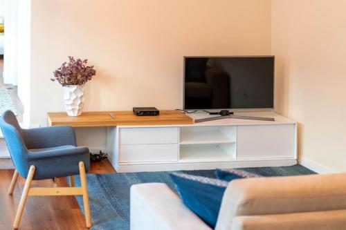 a living room with a television on a white entertainment center at City Center Apartments-Penafiel in Penafiel