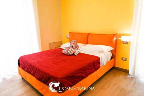 a bedroom with an orange bed with a red comforter at Domus Marina - Ionio room in Mondragone
