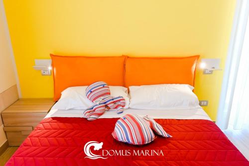 a bed with two striped pillows on top of it at Domus Marina - Ionio room in Mondragone