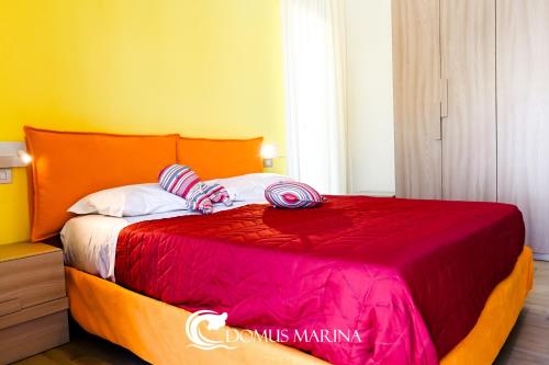 a bedroom with a bed with an orange and red blanket at Domus Marina - Ionio room in Mondragone