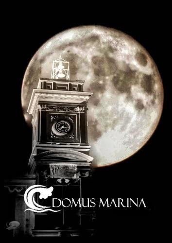 a clock tower with the moon in the background at Domus Marina - Ionio room in Mondragone