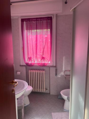 bagno con finestra rosa, lavandino e servizi igienici di B&B Marco bianca a Badia Polesine