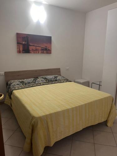 una camera da letto con un grande letto con copriletto giallo di B&B Marco bianca a Badia Polesine