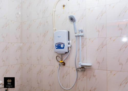 a bathroom with a blow dryer on a wall at Nile Homestay in Jinja