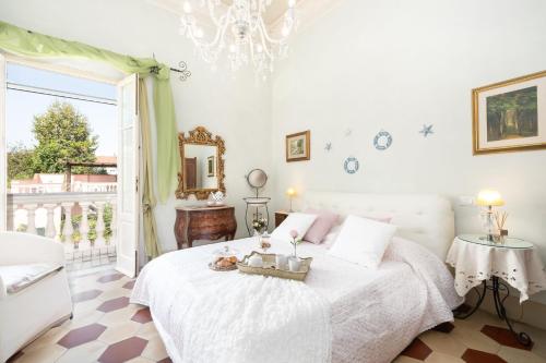 a bedroom with a white bed and a chandelier at Villa Lola - Liberty Dreamscape in Viareggio