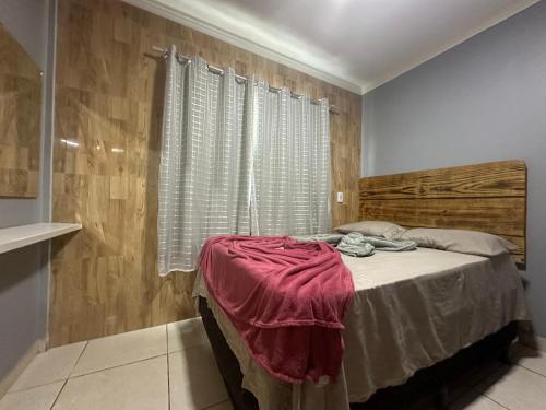 1 dormitorio con 1 cama y pared de madera en AP inteiro com ar condicionado en Goiânia