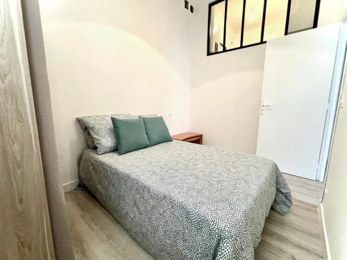 - une petite chambre avec un lit et un oreiller vert dans l'établissement La Villa Riquet Menton, à Menton