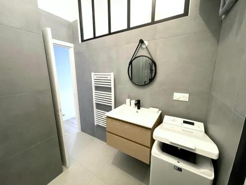 une salle de bain avec un lavabo blanc et un miroir dans l'établissement La Villa Riquet Menton, à Menton