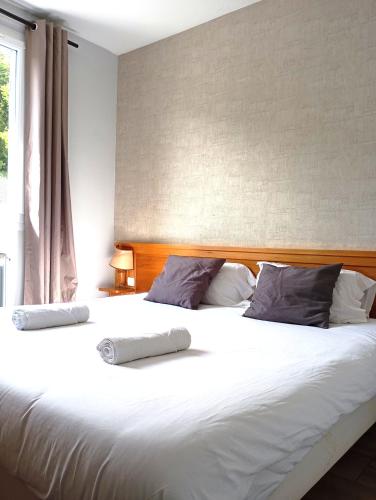 une chambre avec un grand lit blanc avec une fenêtre dans l'établissement Évasion Hébergement, à Allevard