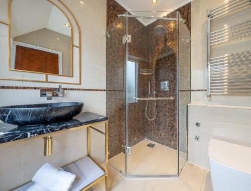 y baño con lavabo y ducha acristalada. en The Grosvenor Residences en Londres
