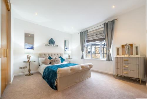 Habitación blanca con cama y ventana en The Grosvenor Residences en Londres