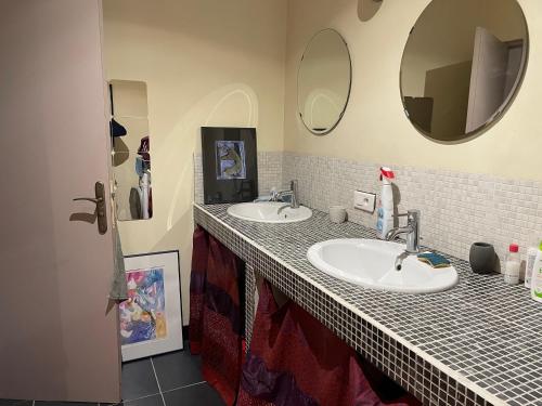 une salle de bain avec deux lavabos et deux miroirs dans l'établissement Maison indépendante à Sainte-Lucie de Tallano, à Santa-Lucia-di-Tallano