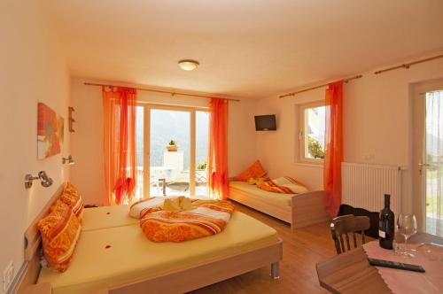 a living room with a bed and a couch and a table at Gasthaus Jaufenblick in San Martino
