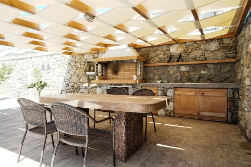 a kitchen with a wooden table and chairs at Filokalia 4 Veins - Vacation House with Sea View in Karistos