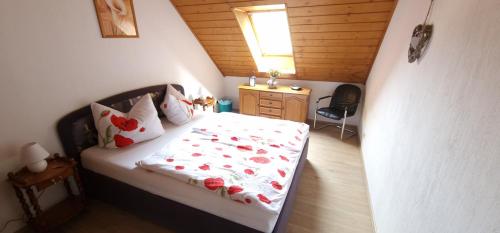 a bedroom with a bed with red flowers on it at Ferienwohnung Lange in Kurort Jonsdorf