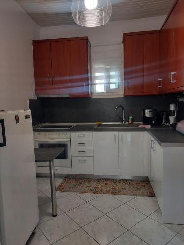 a kitchen with white cabinets and a white refrigerator at Seaside Gate House in Ofrínion